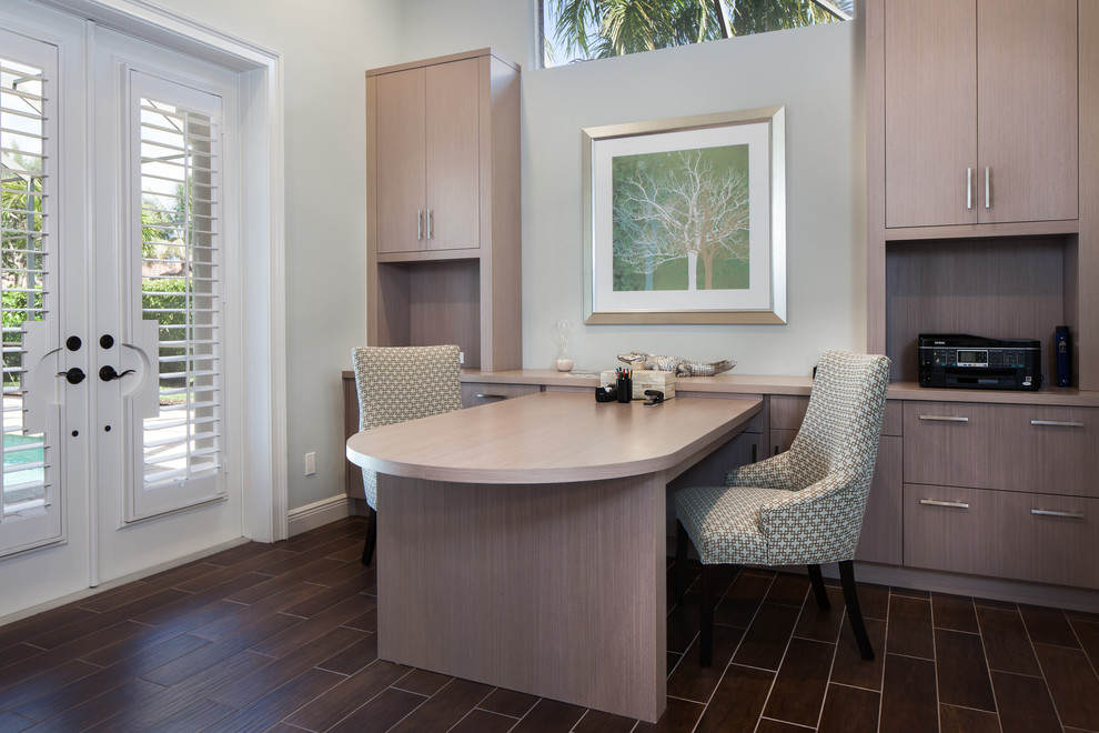 This is an example of a mid-sized modern study room in Miami with ceramic floors, a built-in desk and grey walls.