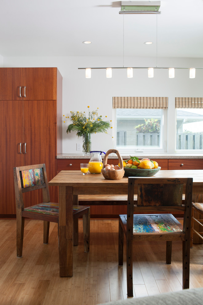This is an example of a contemporary kitchen/dining combo in Hawaii with white walls and medium hardwood floors.