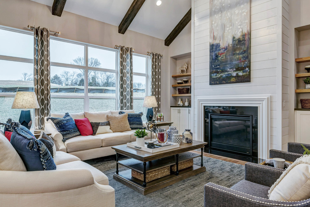 Inspiration for a large transitional open concept living room in St Louis with grey walls, a standard fireplace, a stone fireplace surround and light hardwood floors.