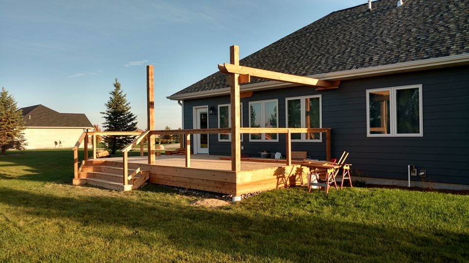 Large mountain style deck photo with a pergola