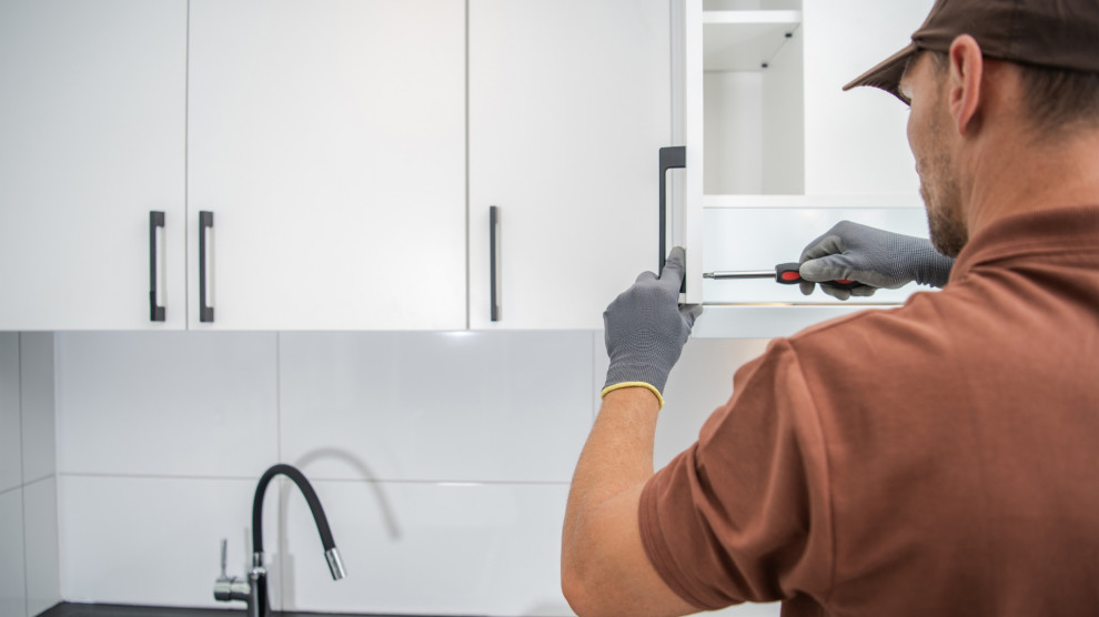 Kitchen cabinets being refinished, showing a cost-saving alternative to replacing them.