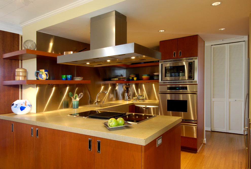 Inspiration for a small modern kitchen in Seattle with flat-panel cabinets, medium wood cabinets, concrete benchtops, stainless steel appliances, bamboo floors and a peninsula.