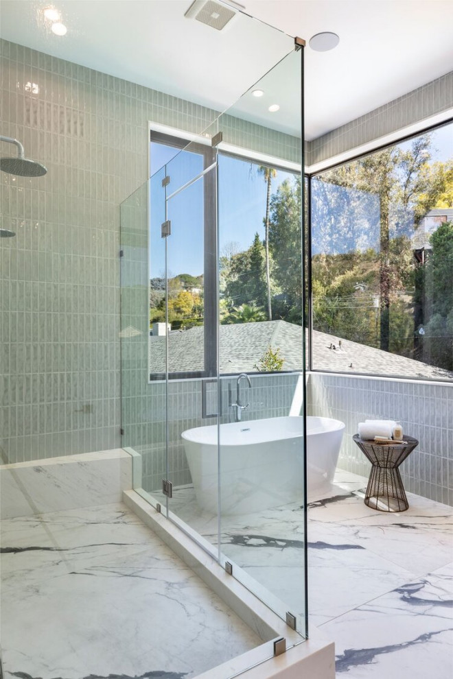 Design ideas for a large contemporary master bathroom in Los Angeles with louvered cabinets, medium wood cabinets, a freestanding tub, a corner shower, a one-piece toilet, gray tile, porcelain tile, marble floors, an undermount sink, marble benchtops, white floor, a hinged shower door, white benchtops, a double vanity and a freestanding vanity.