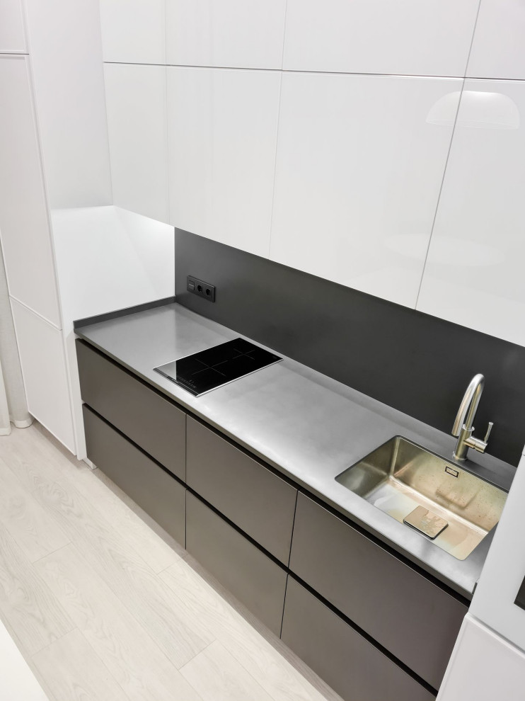 Idee per una piccola cucina contemporanea con top in superficie solida, paraspruzzi nero, pavimento in vinile, pavimento bianco e top bianco
