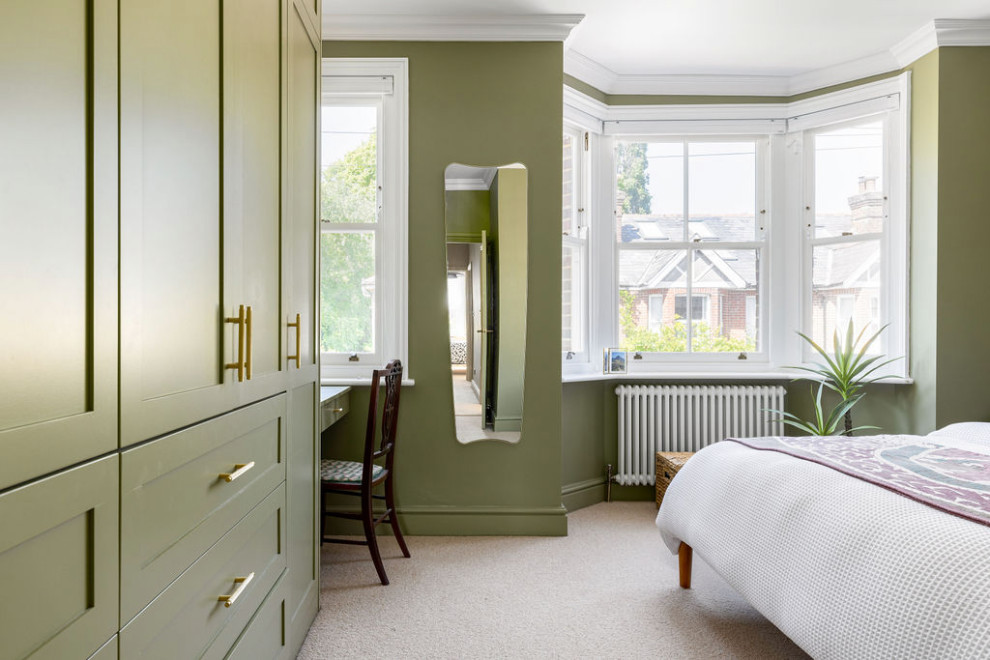Diseño de dormitorio principal retro de tamaño medio sin chimenea con paredes verdes, moqueta y suelo beige