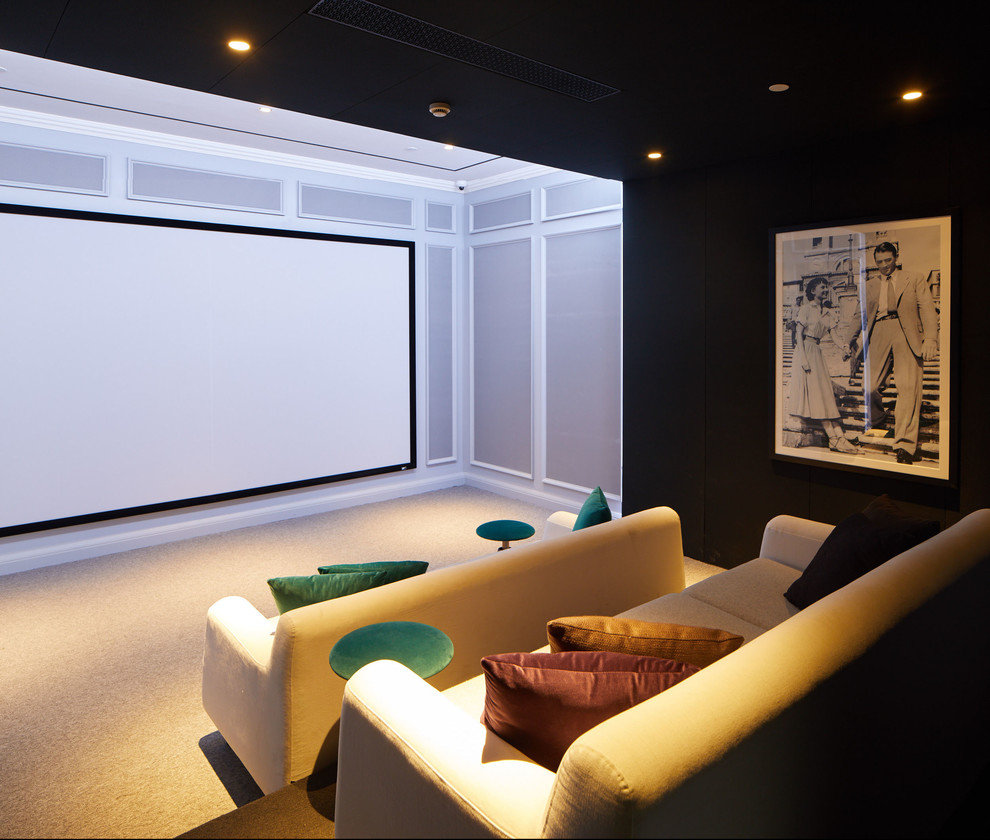 This is an example of a large home theatre in Other with multi-coloured walls, carpet, a wall-mounted tv and grey floor.