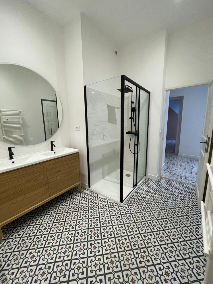 Medium sized contemporary ensuite bathroom in Other with beaded cabinets, light wood cabinets, a submerged bath, a built-in shower, white tiles, metro tiles, white walls, cement flooring, a console sink, solid surface worktops, multi-coloured floors, a sliding door, white worktops, a wall niche and double sinks.