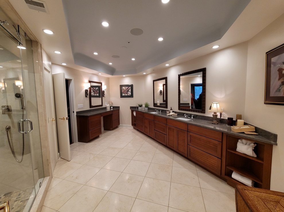 This is an example of an expansive transitional master bathroom in Boston with louvered cabinets, medium wood cabinets, a double shower, a bidet, multi-coloured tile, mosaic tile, beige walls, travertine floors, an undermount sink, granite benchtops, white floor, a hinged shower door, grey benchtops, an enclosed toilet, a double vanity, a built-in vanity and recessed.