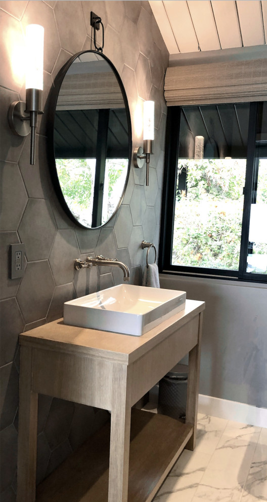 Photo of a mid-sized contemporary 3/4 bathroom in Los Angeles with flat-panel cabinets, beige cabinets, a curbless shower, gray tile, porcelain tile, marble floors, a vessel sink, wood benchtops, white floor, beige benchtops, a single vanity and a freestanding vanity.