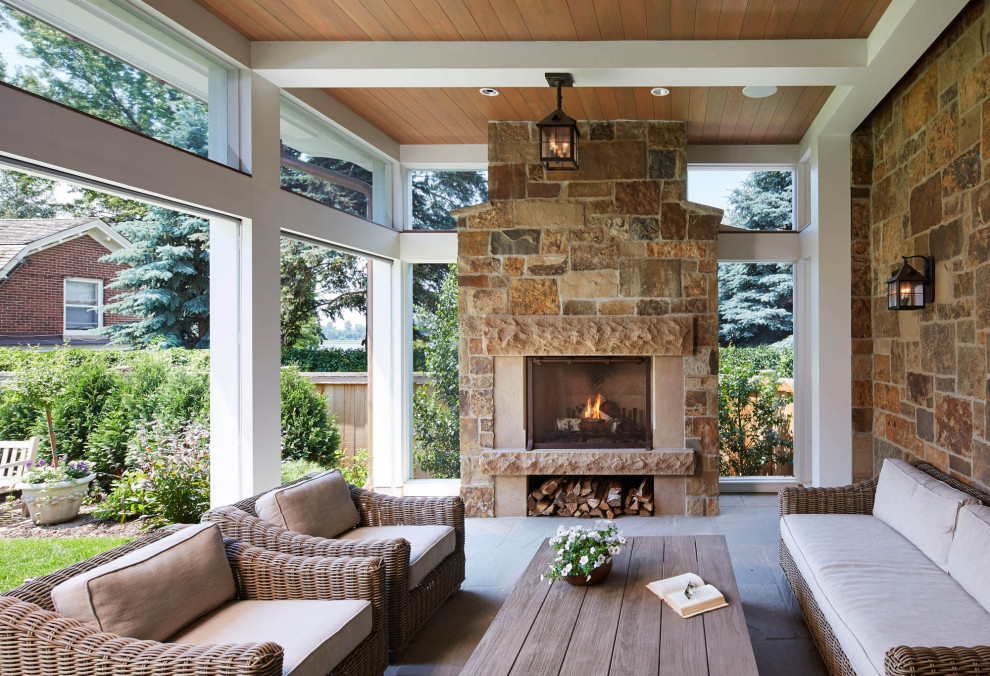 This is an example of a traditional patio in Minneapolis with with fireplace and a roof extension.