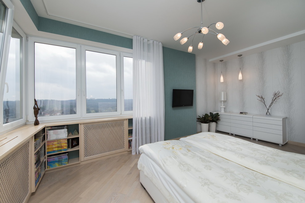 This is an example of a mid-sized contemporary master bedroom in Malaga with blue walls, light hardwood floors, no fireplace and beige floor.