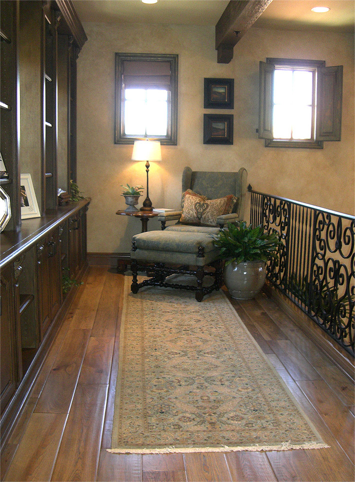 Photo of an expansive mediterranean hallway in Los Angeles with beige walls, porcelain floors and brown floor.