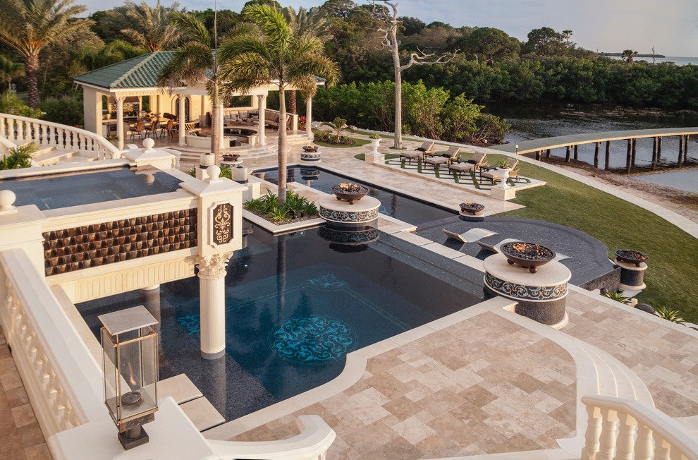 Photo of an expansive mediterranean backyard custom-shaped infinity pool in Tampa with a hot tub.