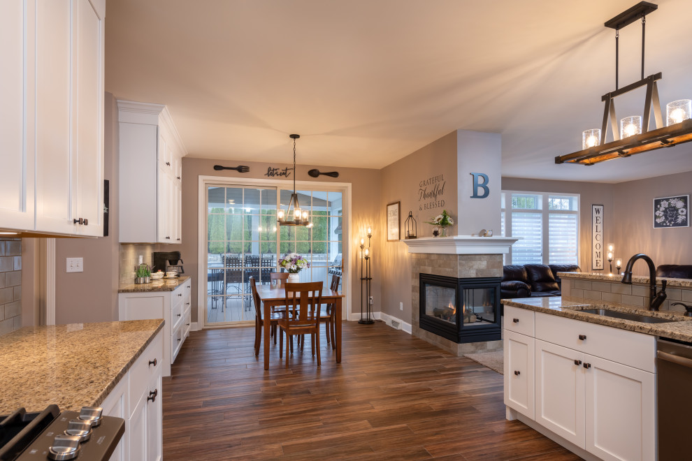 Inspiration for a mid-sized transitional galley open concept kitchen remodel with an undermount sink, shaker cabinets, white cabinets, granite countertops, green backsplash, subway tile backsplash, stainless steel appliances, an island and multicolored countertops
