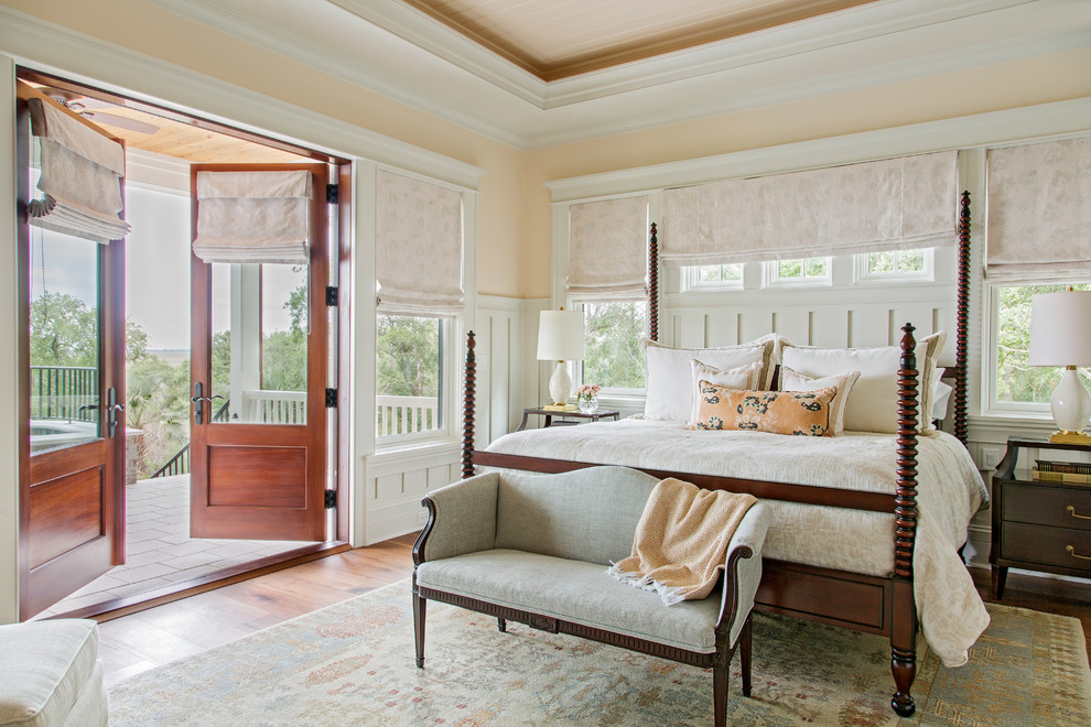 This is an example of a large traditional master bedroom in Charleston with pink walls and medium hardwood floors.