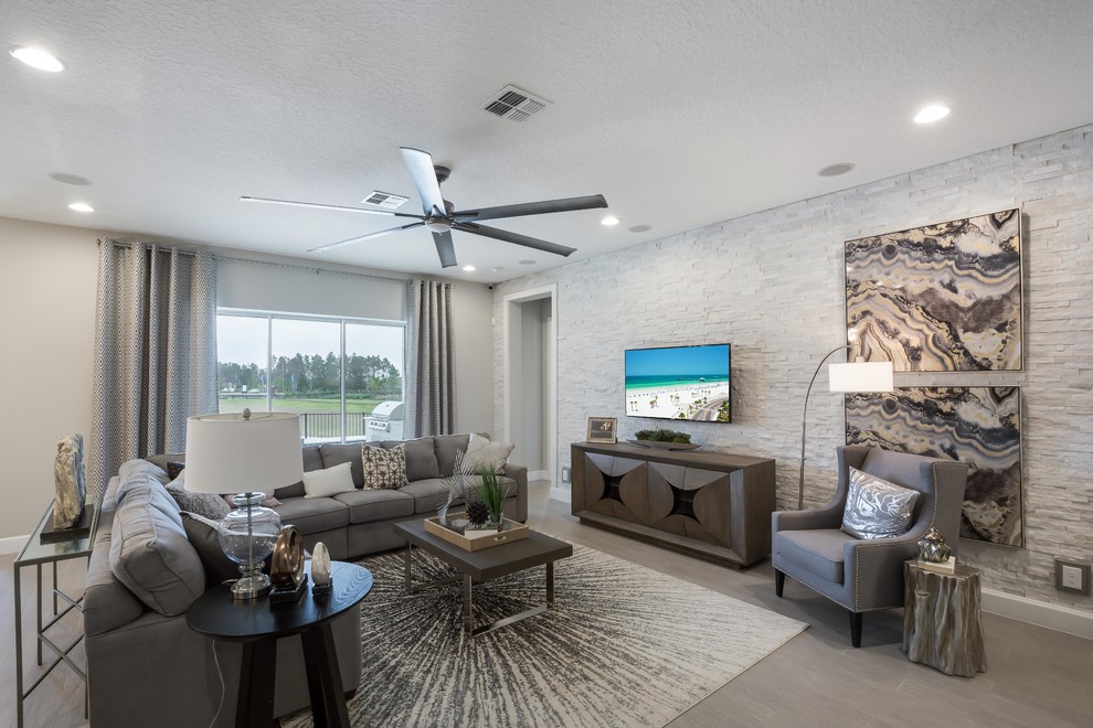 This is an example of a transitional living room in Orlando with grey walls, a wall-mounted tv and grey floor.