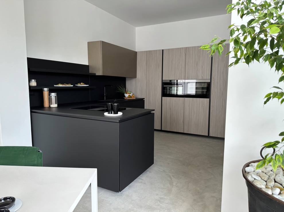 Inspiration for a large modern u-shaped open plan kitchen in Other with flat-panel cabinets, black cabinets, laminate benchtops, black splashback, with island, black benchtop, an undermount sink, stainless steel appliances, concrete floors and grey floor.