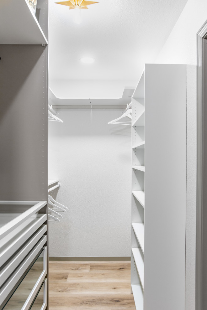 Idee per un grande armadio incassato minimalista con ante di vetro, ante bianche, pavimento in vinile e pavimento beige