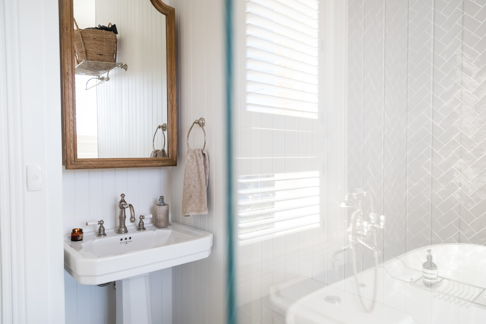 Inspiration for a mid-sized traditional master wet room bathroom in Sydney with a freestanding tub, a one-piece toilet, gray tile, ceramic tile, white walls, marble floors, a pedestal sink, white floor and a hinged shower door.