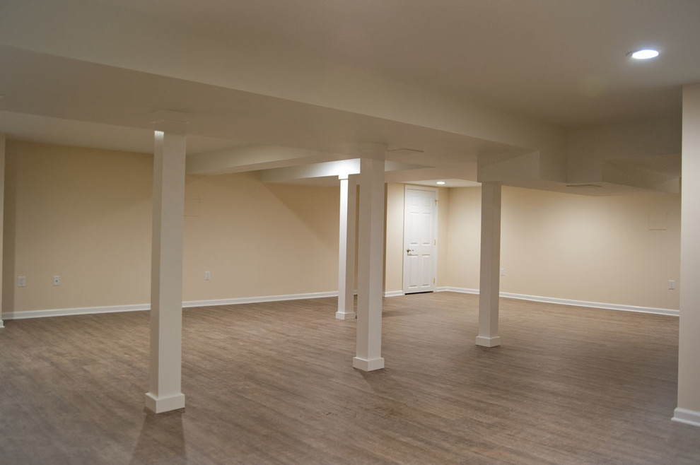 Design ideas for a mid-sized transitional fully buried basement in New York with beige walls, no fireplace and dark hardwood floors.