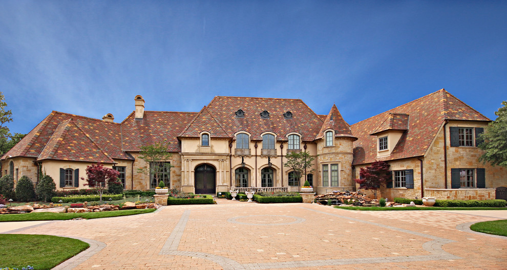 Design ideas for an expansive traditional two-storey stucco beige house exterior in Dallas with a tile roof.