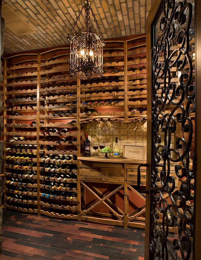 This is an example of an expansive mediterranean wine cellar in Phoenix with dark hardwood floors and storage racks.