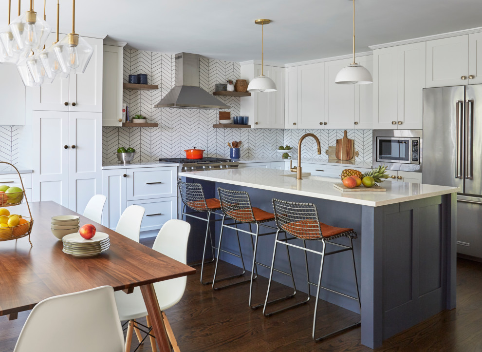 Design ideas for a transitional u-shaped eat-in kitchen in Chicago with a farmhouse sink, shaker cabinets, white cabinets, white splashback, stainless steel appliances, medium hardwood floors, with island, brown floor and white benchtop.