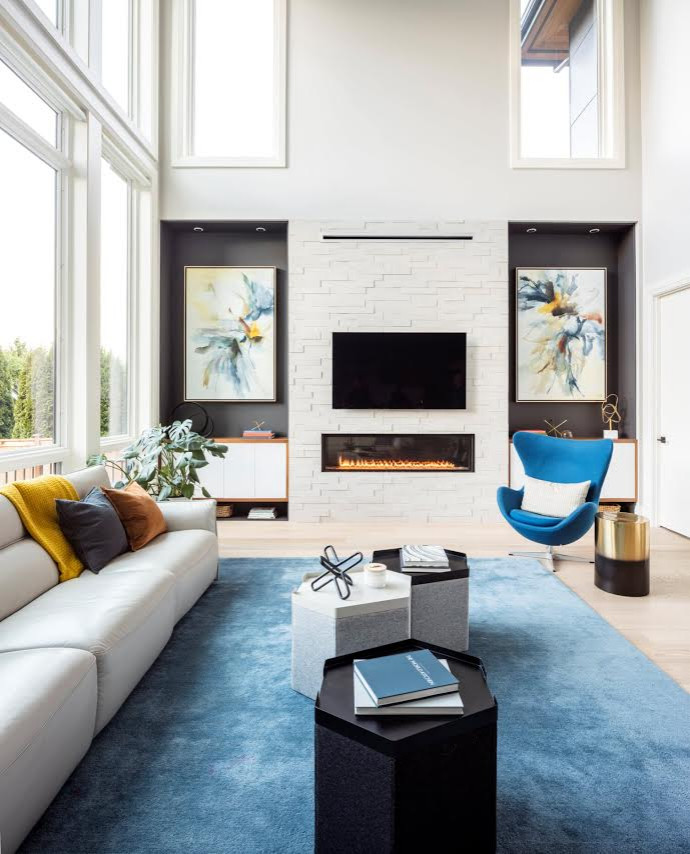 Large modern living room in Seattle with light hardwood floors, a standard fireplace, a stone fireplace surround and beige floor.