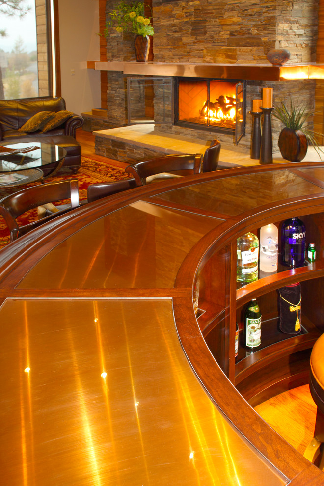 Inspiration for a mid-sized arts and crafts u-shaped seated home bar in Seattle with a drop-in sink, raised-panel cabinets, dark wood cabinets, wood benchtops, mirror splashback and medium hardwood floors.