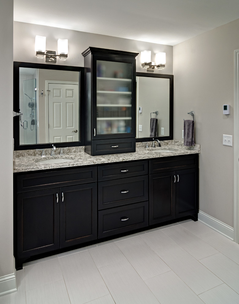 Photo of a mid-sized transitional master bathroom in Minneapolis with a two-piece toilet, grey walls, porcelain floors, an undermount sink, white tile, porcelain tile, shaker cabinets, black cabinets, an undermount tub, granite benchtops, an alcove shower and grey benchtops.