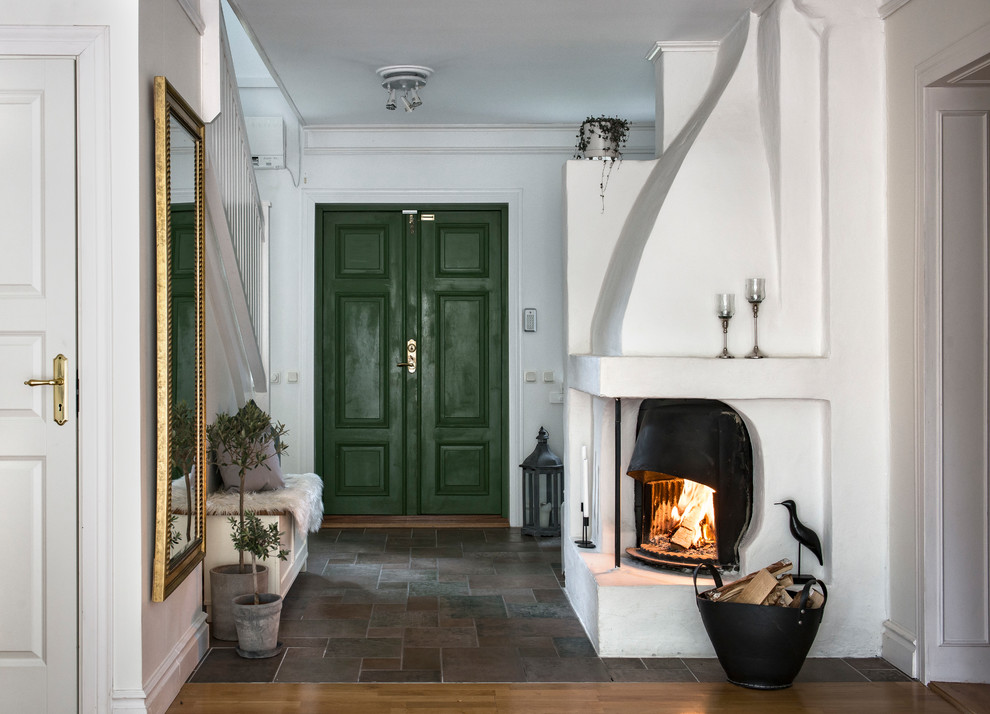Photo of a mid-sized traditional entry hall in Stockholm with white walls, grey floor, a double front door and a green front door.