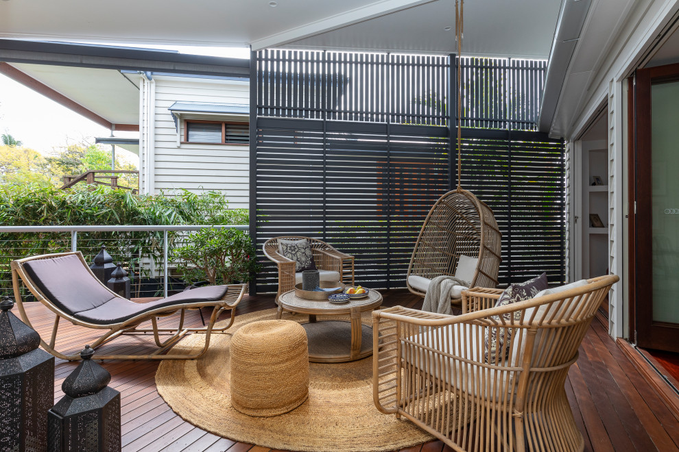 Photo of a contemporary deck in Brisbane with a roof extension and cable railing.