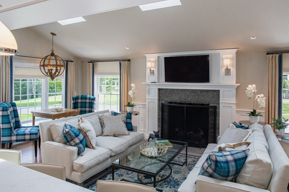 Photo of a mid-sized beach style open concept family room in Bridgeport with grey walls, medium hardwood floors, a standard fireplace, a stone fireplace surround, a wall-mounted tv, brown floor, wallpaper and wallpaper.