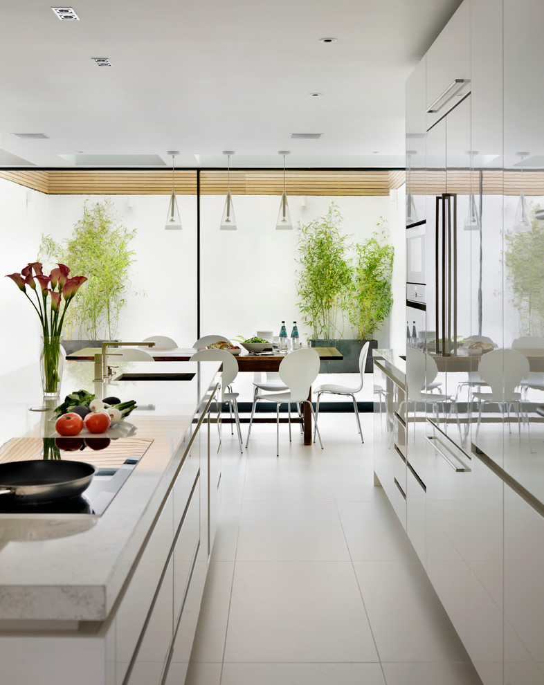 Design ideas for a large contemporary open plan kitchen in London with an undermount sink, flat-panel cabinets, solid surface benchtops, with island and white cabinets.