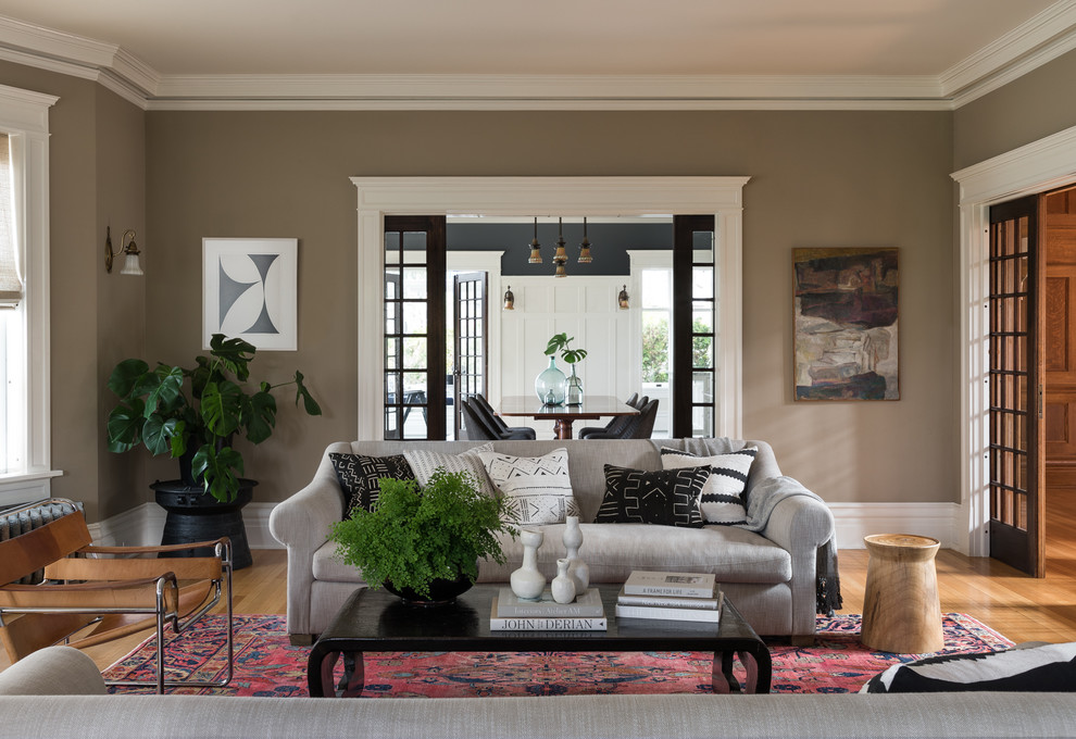 Inspiration for a mid-sized arts and crafts formal open concept living room in Seattle with grey walls, medium hardwood floors, no fireplace, no tv and beige floor.