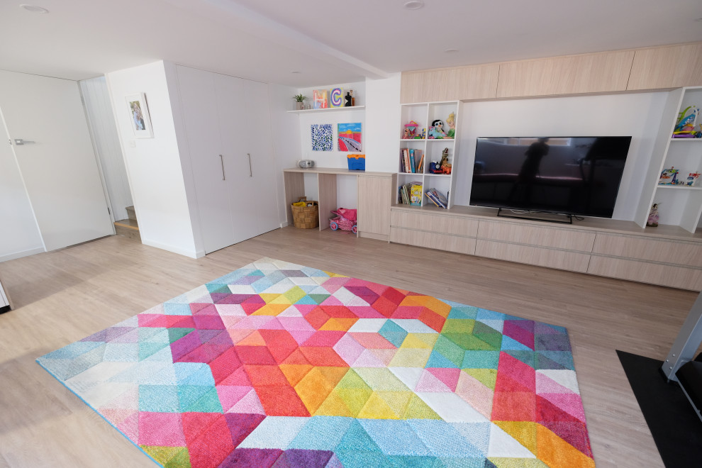 Photo of a large contemporary kids' playroom for kids 4-10 years old in Sydney with white walls and vinyl floors.
