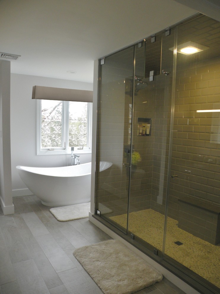 Photo of a modern master bathroom in Philadelphia with shaker cabinets, dark wood cabinets, a freestanding tub, a double shower, a one-piece toilet, gray tile, ceramic tile, grey walls, ceramic floors, an undermount sink and quartzite benchtops.