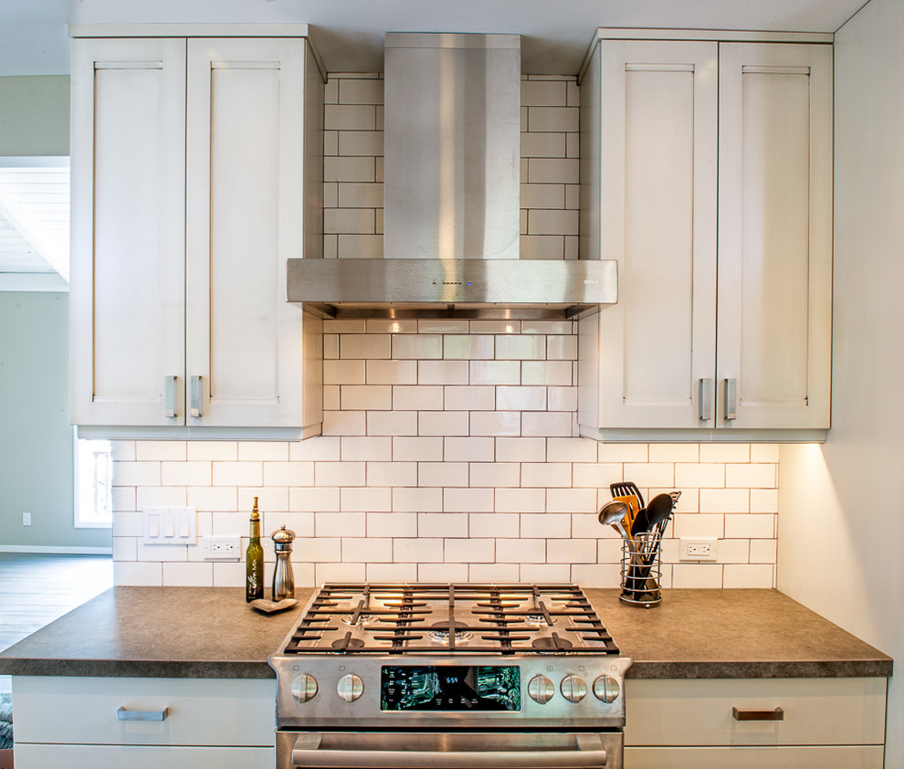 Inspiration for a large transitional u-shaped separate kitchen in San Francisco with an undermount sink, shaker cabinets, white cabinets, zinc benchtops, white splashback, subway tile splashback, stainless steel appliances, dark hardwood floors, a peninsula and brown floor.