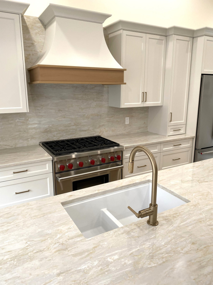 Example of a small transitional galley light wood floor and vaulted ceiling open concept kitchen design in Toronto with an undermount sink, recessed-panel cabinets, white cabinets, quartz countertops, quartz backsplash and stainless steel appliances
