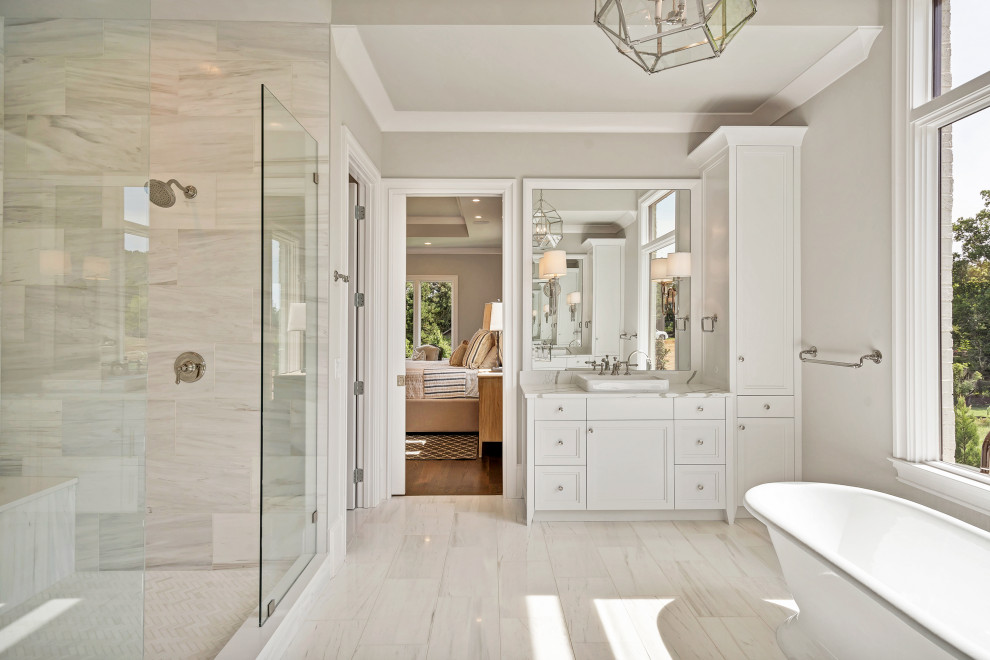 Mid-sized transitional master beige tile, gray tile and porcelain tile porcelain tile and beige floor freestanding bathtub photo in Atlanta with white cabinets, gray walls, a vessel sink, quartz countertops, recessed-panel cabinets and gray countertops
