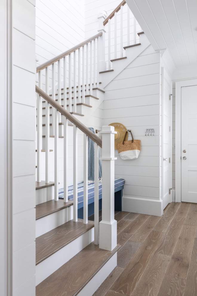 Inspiration for a large nautical wood u-shaped wood railing staircase in Other with painted wood risers and tongue and groove walls.