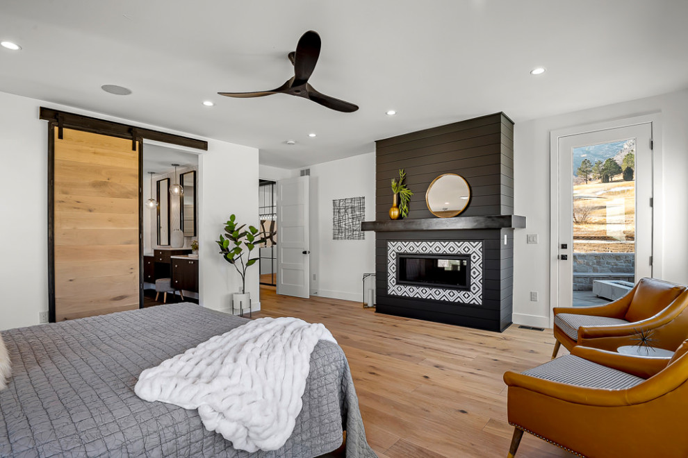 Large minimalist master light wood floor and brown floor bedroom photo in Denver with white walls, a standard fireplace and a shiplap fireplace