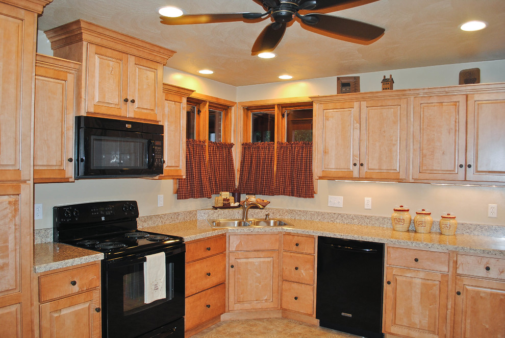 Enclosed kitchen - mid-sized l-shaped enclosed kitchen idea with a double-bowl sink, raised-panel cabinets, light wood cabinets, black appliances and no island