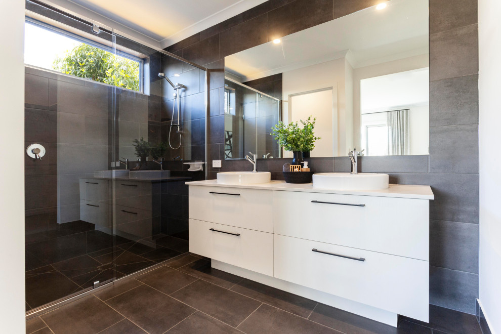 Photo of a contemporary bathroom in Melbourne with white cabinets, gray tile, ceramic tile, grey walls, ceramic floors, engineered quartz benchtops, grey floor, white benchtops, flat-panel cabinets, an alcove shower, a vessel sink, a sliding shower screen and a double vanity.