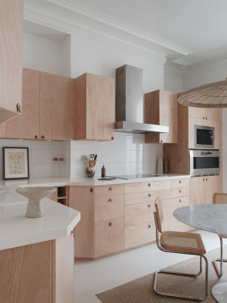 Expansive scandinavian l-shaped enclosed kitchen in Paris with a submerged sink, beaded cabinets, light wood cabinets, composite countertops, white splashback, porcelain splashback, stainless steel appliances, concrete flooring, no island, white floors and white worktops.