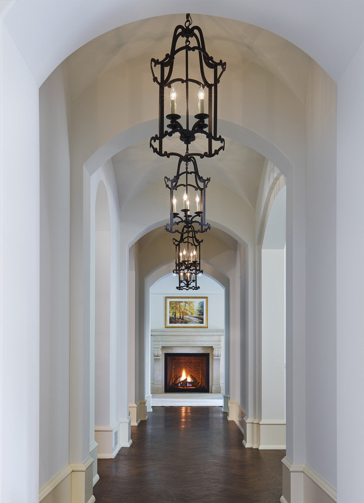 This is an example of a large traditional hallway in Minneapolis with white walls, dark hardwood floors and brown floor.