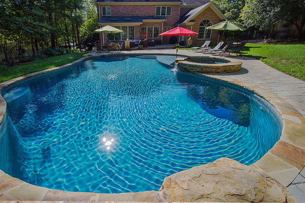 Hot tub - large rustic backyard concrete paver and custom-shaped natural hot tub idea in Raleigh