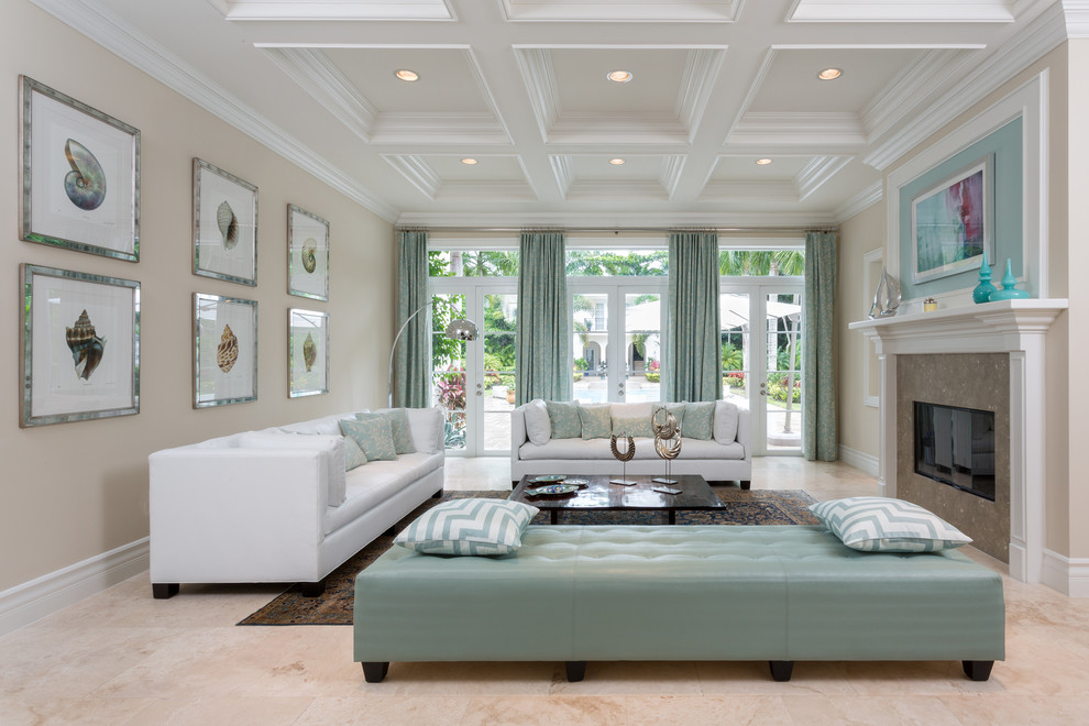 Photo of an expansive beach style formal open concept living room in Miami with beige walls, limestone floors, a standard fireplace, a tile fireplace surround, no tv and beige floor.