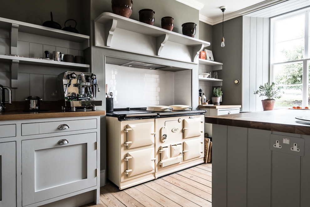Inspiration for a country galley eat-in kitchen in Edinburgh with shaker cabinets, grey cabinets, white splashback, light hardwood floors, with island and wood benchtops.