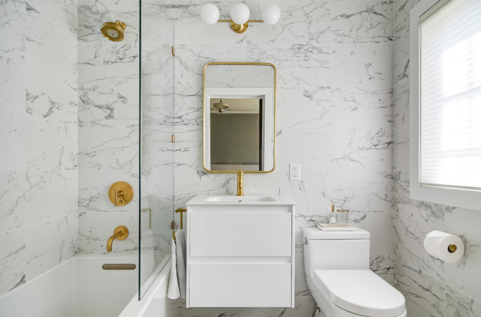 This is an example of a small contemporary master bathroom in Minneapolis with flat-panel cabinets, a drop-in tub, a two-piece toilet, porcelain tile, marble floors, an integrated sink and an open shower.